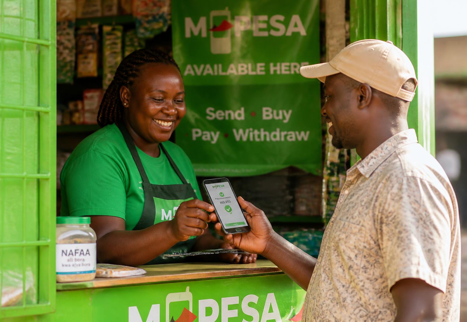 Shopkeeper accepting an M-Pesa payment on a phone